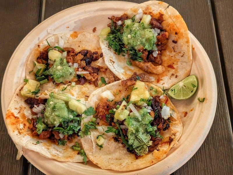 Three soft tacos topped with cilantro, onions, avocado and a lime wedge on a plate at Big Bend National Park.