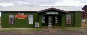 Green, single-story restaurant building in Big Bend National Park with a white metal roof and a small front porch.