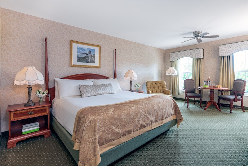 Luxurious Bar Harbor hotel room with a king bed, elegant bedding, and warm decor in Acadia National Park.