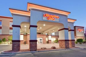Exterior view of a hotel entrance with stone columns and an arched driveway in Arches National Park area.