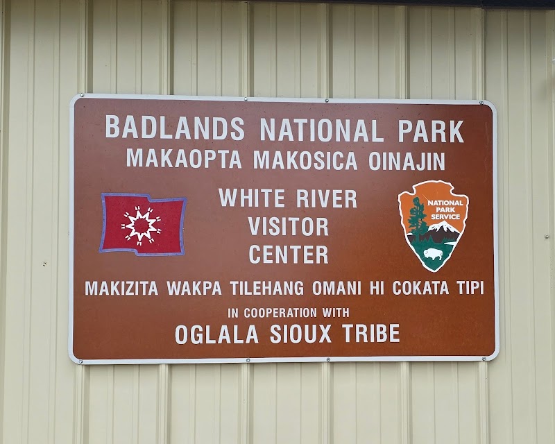 Brown Badlands National Park sign mounted on a beige wall with large white letters and National Park Service logos.