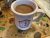 White ceramic mug of coffee sits on a colorful terrazzo table embedded with seashells in a cafe setting at Acadia National Park.