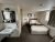 Cozy lodge room at Yellowstone National Park near Old Faithful, featuring a bed, nightstand, and sink area in a simple, well-lit setting.