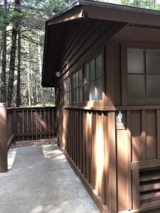 Wooden bathhouse at Blackwoods Campground in Acadia National Park, with brown siding and forest backdrop.