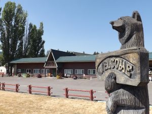 Glacier National Park scene with a large carved bear statue at the resort entrance.