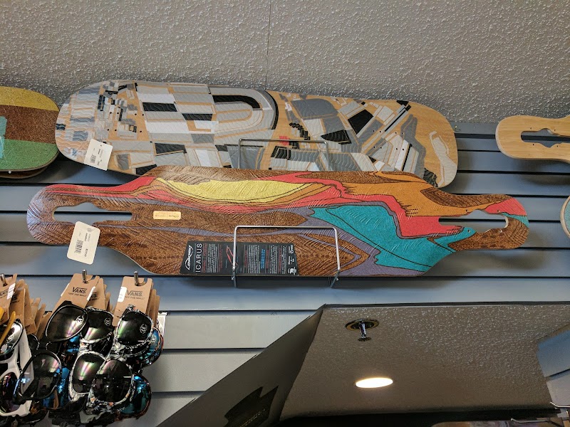 Colorful wooden longboards with abstract designs hang on a slat-wall display in a gift shop at Acadia National Park.
