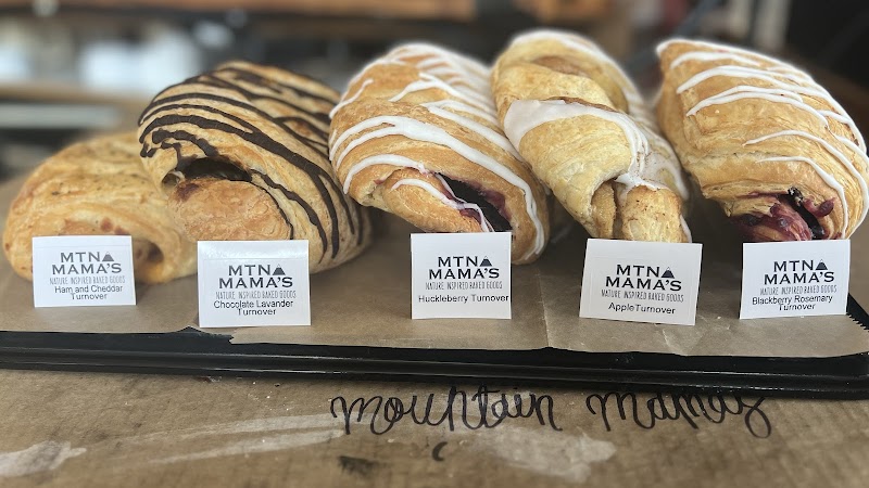 Assorted croissants with dark and white drizzle sit on a display tray at Yellowstone National Park cafe.