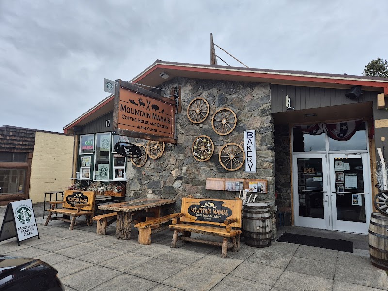 Rustic stone storefront in Yellowstone National Park with wagon wheels on the wall, wood benches, and bakery signage.
