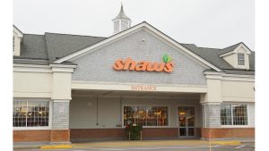 Gift shop exterior at Acadia National Park, with a gray shingle facade, orange sign, and large front windows.