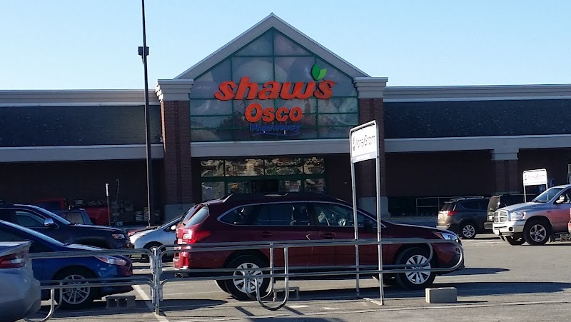Gift shop storefront in Acadia National Park's village area, with cars in the lot and a bright sky.