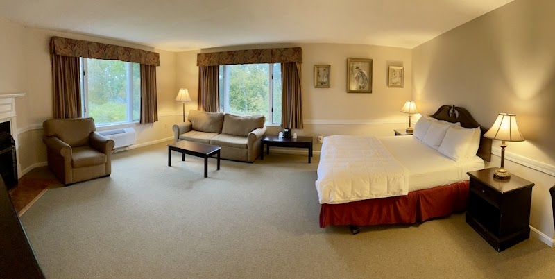 Interior of a lodging room in Acadia National Park with a king bed, sofa, and two windows.