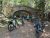 Bikes rest near a stone arch bridge on a forested carriage road in Acadia National Park.
