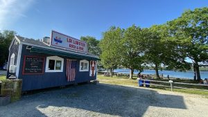 Lobster dock restaurant at Acadia National Park, blue building with flags by the seaside.