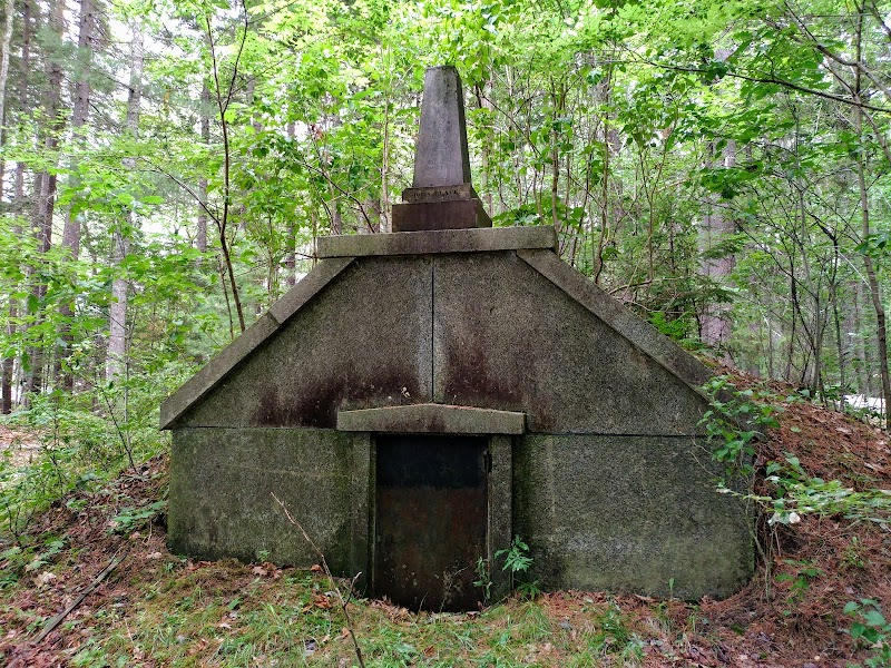 Stone museum ruin at Woodlawn in Acadia National Park, a forested stone structure surrounded by green trees.
