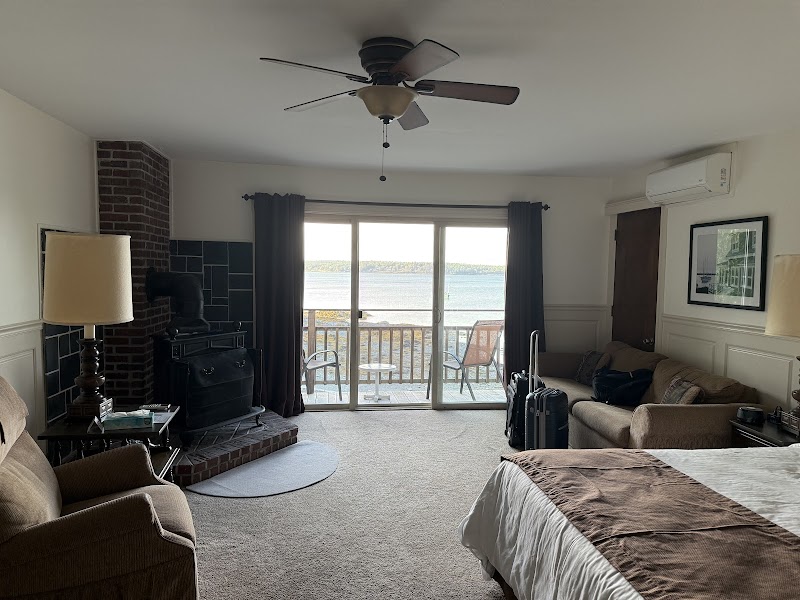 Lodging room with sliding glass door to a balcony overlooking Acadia National Park coastline.