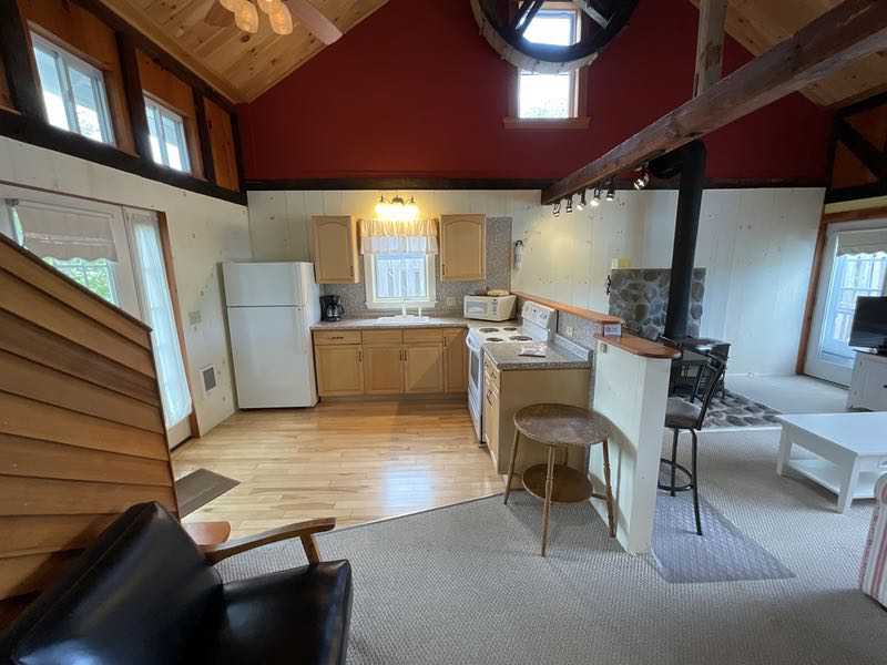 Cozy lodge kitchen at a seaside lodging in Acadia National Park, wood beams and warm lighting.