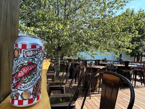 Outdoor dining deck at Acadia National Park with numerous chairs and a decorative patterned beverage can resting on a railing.