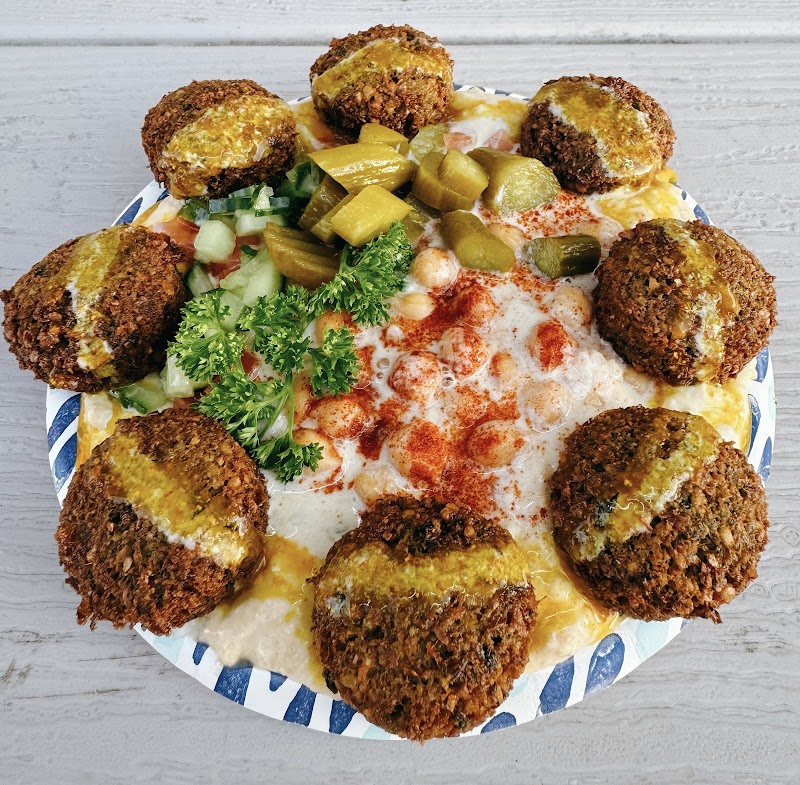 Crispy falafel balls surround a creamy white sauce with paprika, pickle relish and parsley in Yellowstone National Park.