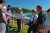 Group of visitors at the Whale Watching overlook in Redwood National and State Parks, examining an interpretive sign about local marine life with coastline beyond.