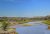 The Little Missouri River winds through Theodore Roosevelt National Park's badlands under a clear blue sky.