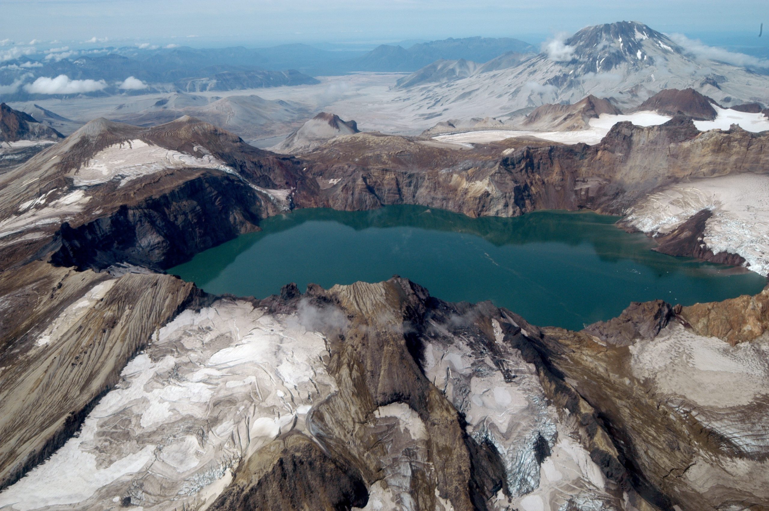 Novarupta crater lake in Katmai National Park & Preserve, Alaska, sits emerald-green in a rugged volcanic caldera surrounded by snow-dusted ridges.