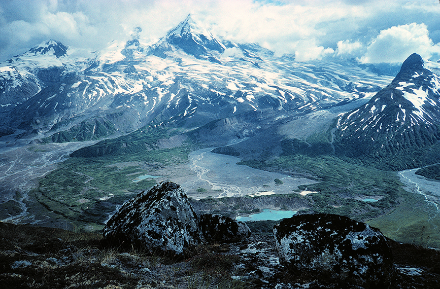 View from a high overlook in Lake Clark National Park & Preserve, revealing snow-capped peaks, glaciers, and turquoise lakes.