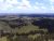 Panoramic view from Rankin Ridge Overlook in Wind Cave National Park, showing rolling prairie and pine clusters under a blue sky.