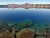 Crater Lake shoreline at Crater Lake National Park with clear blue water and a rocky foreground along the calm lake surface.
