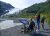 Visitors at the Exit Glacier overlook in Kenai Fjords National Park, with the glacier carving a blue tongue behind green hills.
