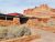 Capitol Reef National Park Visitor Center sits among red sandstone walls with a low, flat roof and desert shrubs in the foreground.