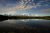 Snowy Denali rises behind Wonder Lake with a glassy foreground reflecting the mountain and sky.