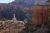 Hikers traverse a sandy Bryce Canyon trail beside towering orange hoodoos in Bryce Canyon National Park under clear blue sky.