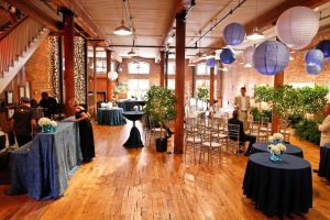Gift shop interior at Congaree National Park features blue-tablecloth displays and hanging lanterns for a gallery-style event.