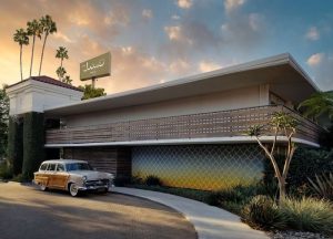 Goleta retro motel exterior with palm trees and a vintage car under a warm sunset.