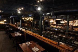 Inside a rustic restaurant dining room at Congaree National Park, long wooden booths line a dimly lit interior.