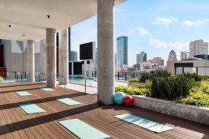 Rooftop pool deck with mint-green mats and Miami skyline above Biscayne National Park area.