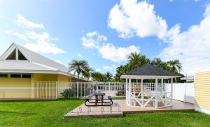 Palm Garden gazebo at Biscayne National Park provides a shaded picnic area beside a bright yellow building.