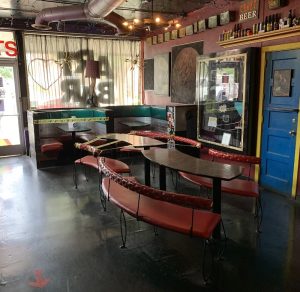 Interior bar space in Congaree National Park, featuring red booths, curved benches, and eclectic retro decor.
