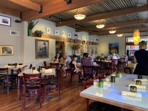 Interior dining room of a Zion National Park restaurant with wooden beams and art on the walls.