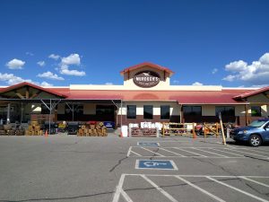 Gift shop exterior at Black Canyon of the Gunnison National Park entrance, with bright blue sky and parking lot in front.