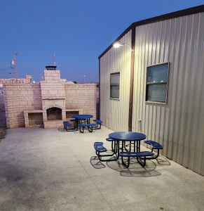 Carlsbad Caverns National Park lodge courtyard with blue metal picnic tables and a brick outdoor grill.