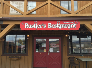 Exterior of a rustic dining lodge at Bryce Canyon National Park with a red double door entrance.