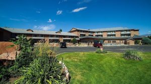 Lodge-style lodging complex in Canyonlands National Park with a manicured lawn and parking lot.