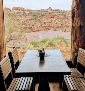 Rustic dining area with canyon view at Capitol Reef National Park, framed by wooden posts and desert brush.