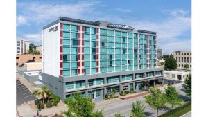 Exterior view of a modern downtown Columbia hotel with teal glass panels, near Congaree National Park in South Carolina.