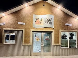 Cafe storefront at Capitol Reef National Park in a brick building lit for night viewing, with snow on the ground.