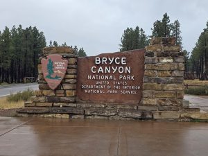 Entrance sign at Bryce Canyon National Park marks the park’s welcome area near the pine forest backdrop.