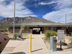 McKittrick Canyon Visitor Center at Carlsbad Caverns National Park, desert landscape with a covered entrance and rugged mountains behind.