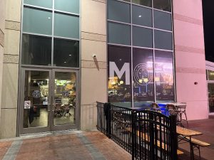 Restaurant storefront exterior with glass doors and outdoor seating near Congaree National Park.