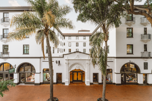 Hotel Santa Barbara entrance at Channel Islands National Park, a white stucco building framed by tall palm trees and an ornate archway.